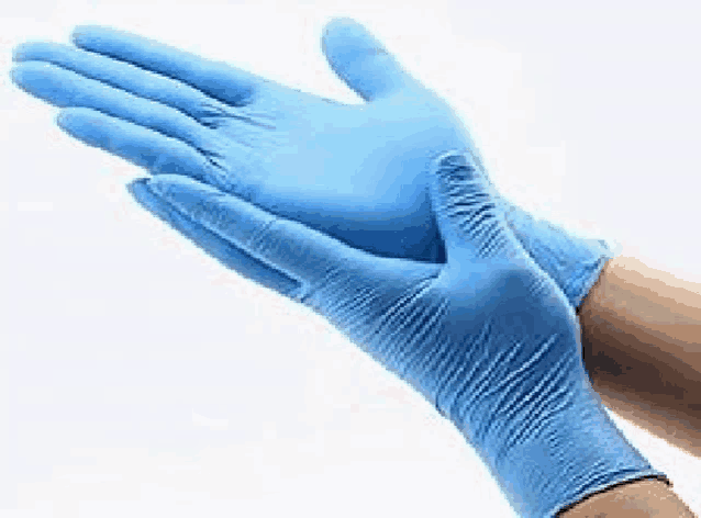 a person wearing a pair of blue latex gloves on their hands .