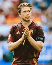 a soccer player wearing a maroon adidas jersey is clapping his hands