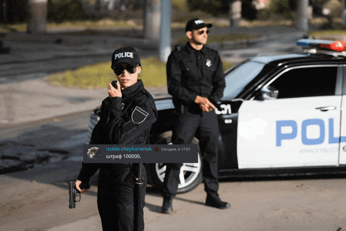 two police officers standing in front of a car that says police