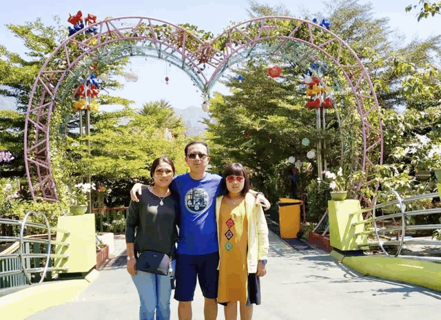 a man wearing a blue shirt that says ' the north face ' on it poses for a picture with two women