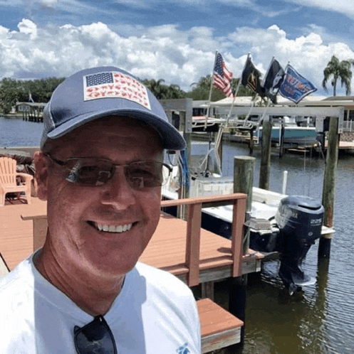 a man wearing a hat with an american flag on it is smiling