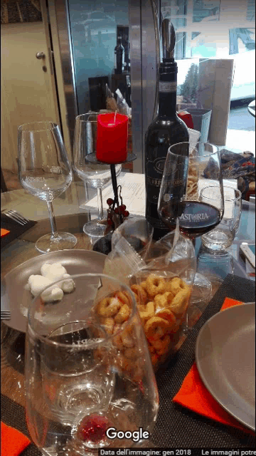 a bottle of wine sits on a table next to a glass of wine