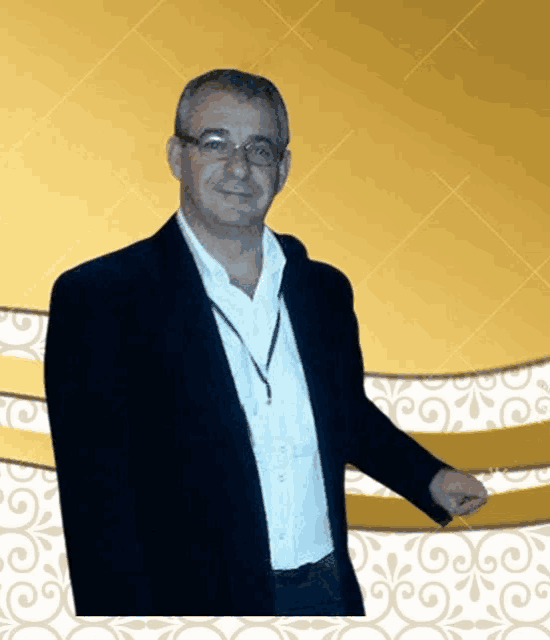 a man with glasses and a lanyard around his neck is standing in front of a gold background