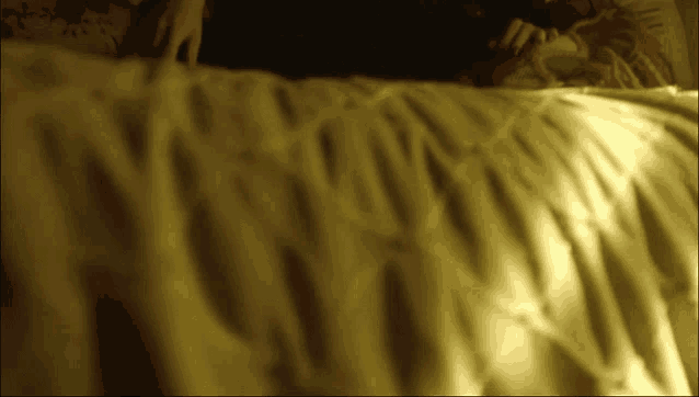 a blurry picture of a person laying on a bed with a yellow blanket