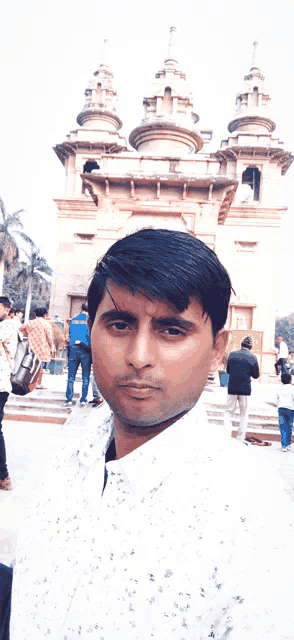 a man poses for a picture in front of a building