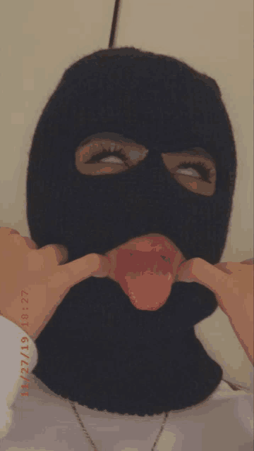 a person wearing a ski mask with their tongue sticking out