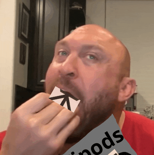 a bald man is holding a piece of paper in his mouth with the word pods on it