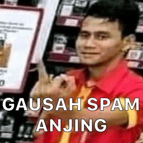 a man in a red shirt is giving the middle finger in a supermarket .