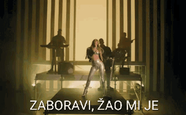 a woman singing into a microphone with the words zaboravi zao mi je on the bottom