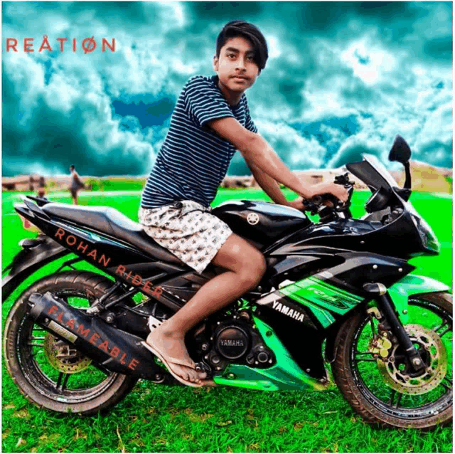 a boy is sitting on a yamaha motorcycle in the grass