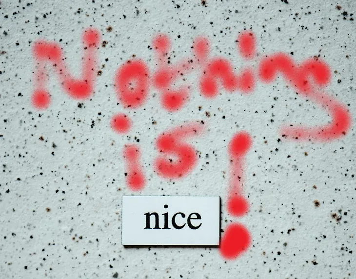 A neutral white background with the word nice, surrounded by the words ‘Nothing is’ in red graffiti.