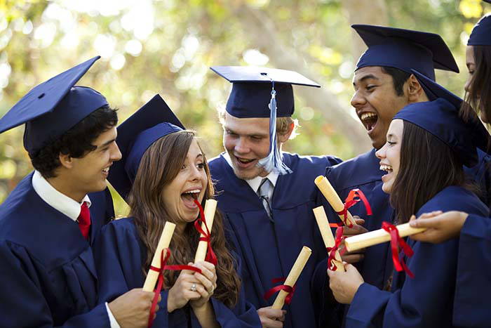 A group of highschoolers in graduation gowns