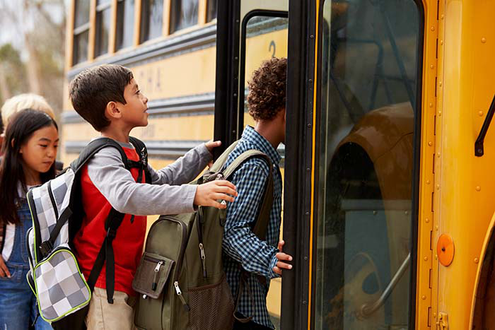 Young children boarding a school bus.