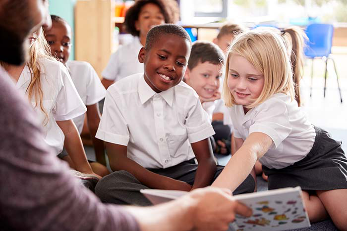 Young children reading with a teacher