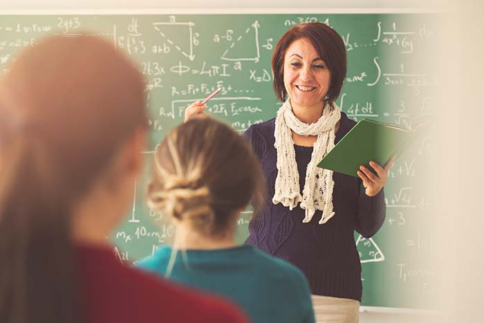 Young girl doing math on a white board