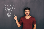 Man pointing at a light bulb drawn on a chalkboard