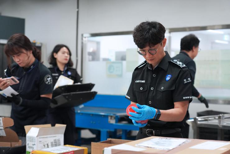 Cho Joo-seong, right, a Korea Customs Service (KCS) officer at KCS Incheon International Airport Regional Customs, and his team members check goods arriving via overseas express shipment at the airport, Friday. Courtesy of KCS