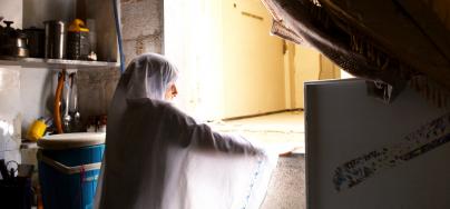 Najwa*, 48, is standing in her partially damaged kitchen in Harasta, Eastern Ghouta, Rural Damascus. 