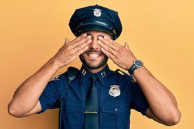 Policeman covering his eyes