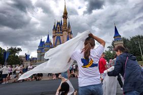 Guests at the Magic Kingdom break out ponchos at Cinderella Castle as bands of weather from Hurricane Helene move through Walt Disney World in Bay Lake, Florida, on Sept. 26, 2024 amid Hurricane Helene.