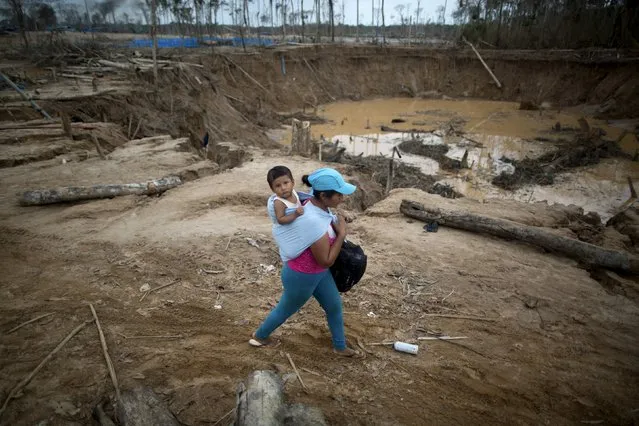 People leave a camp after a Peruvian police operation to destroy illegal gold mining camps in La Pampa, in the southern Amazon region of Madre de Dios, Peru  August 11, 2015. Picture taken August 11, 2015. (Photo by Sebastian Castaneda/Reuters)