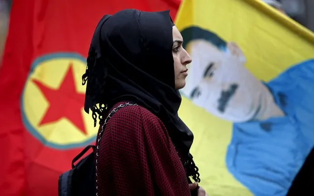 A demonstrator stands between a flag with a picture of Kurdish jailed leader Abdullah Ocalan and a flag of the Kurdistan Workers' Party (PKK) during a march to commemorate the victims of last Saturday's double suicide bombings targeting an Ankara rally of pro-Kurdish activists and civic groups, in Marseille, France, October 17, 2015. (Photo by Jean-Paul Pelissier/Reuters)