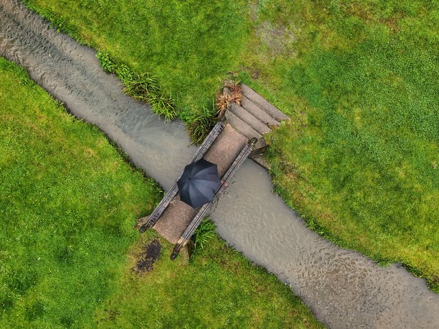 Sue Hall goes for a walk in Charlton village in Worcestershire on Wednesday, May 22, 2024. Heavy rain could bring flooding and travel disruption across much of the UK on Wednesday and Thursday with an amber warning issued for part of the country. (Photo by David Davies/PA Images via Getty Images)