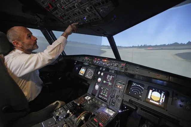 Igor Perne (R), 53, an electronic engineer and a member of the International Virtual Aviation Organisation (IVAO), checks the controls after landing a virtual flight in a flight simulator in Nova Vas November 13, 2014. (Photo by Srdjan Zivulovic/Reuters)