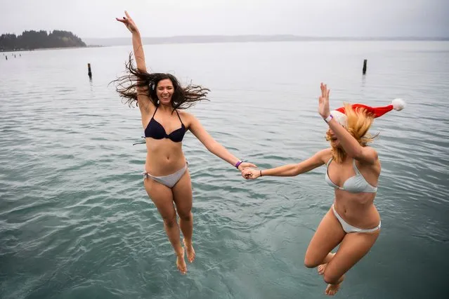 Women jump into the water during a traditional New Year bath in the Adriatic sea in Portoroz, Slovenia on January 1, 2018. (Photo by Jure Makovec/AFP Photo)