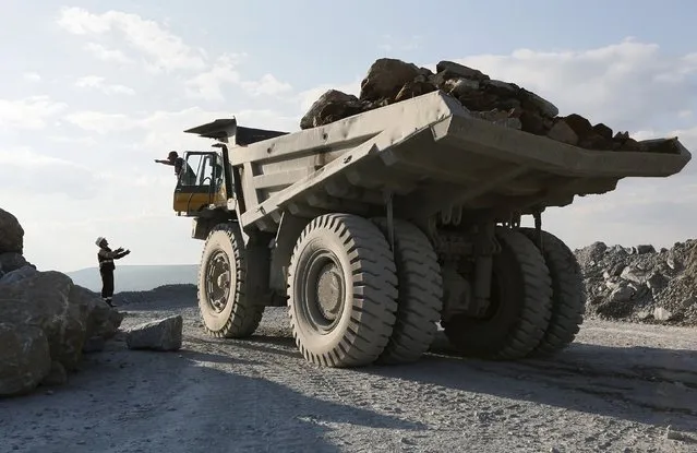 An engineer (L) talks to a driver of a dump truck loaded with gold-bearing soil at the Vostochny opencast of the Olimpiada gold operation, owned by Polyus Gold International company, in Krasnoyarsk region, Eastern Siberia, Russia, June 30, 2015. (Photo by Ilya Naymushin/Reuters)