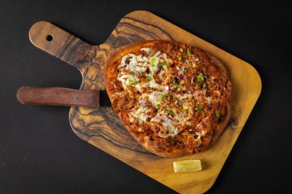 Photo of Curry Up Now - San Francisco, CA, US. a pizza on a cutting board