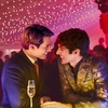 Alex and Henry from Red White and Royal Blue at a New Years party, smiling smittenly at each other