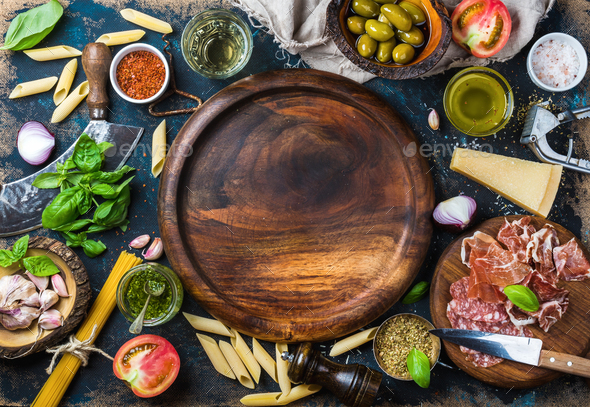 Italian food cooking ingredients on dark plywood background, copy space  Stock Photo by sonyakamoz