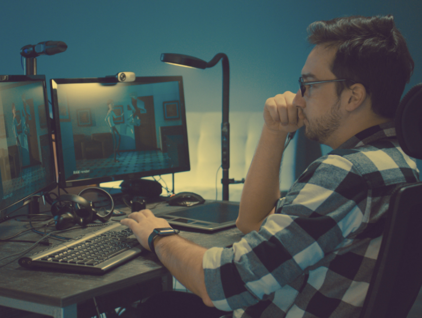 man in plaid sitting behind two computer screens working on an animation | time management tips