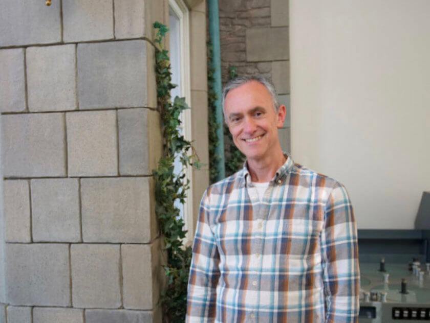 Man in plaid shirt smiling at the camera