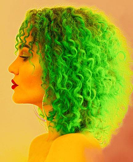 Producer, Vocalist, Performer, DJ and SAE graduate Isabella Piper. Profile portrait of woman with green curly hair. She wears red lipstick.