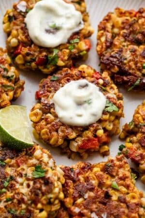 corn fritters with yogurt sauce on top.