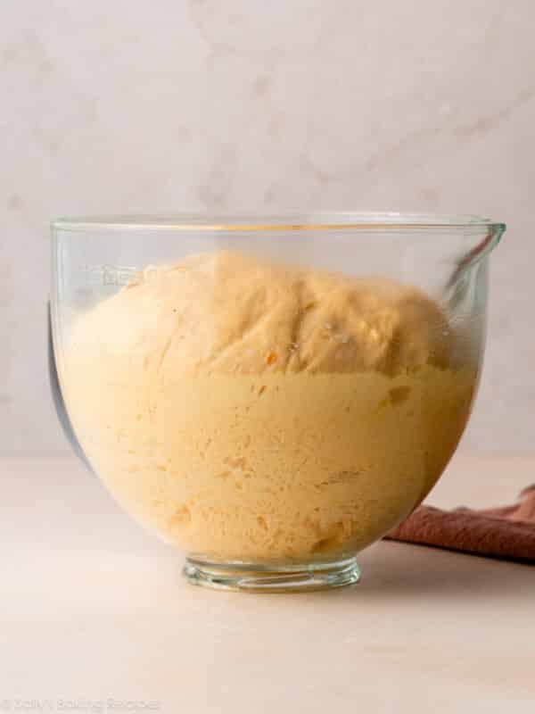 orange-colored dough risen in glass bowl.