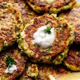 close-up of zucchini fritters with garlic herb Greek yogurt sauce.