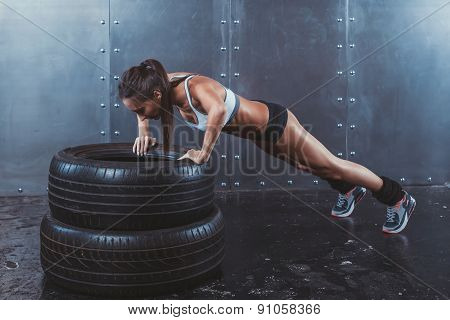 Sportswoman. Fit sporty woman doing push ups on tire strength power training concept fit fitnes