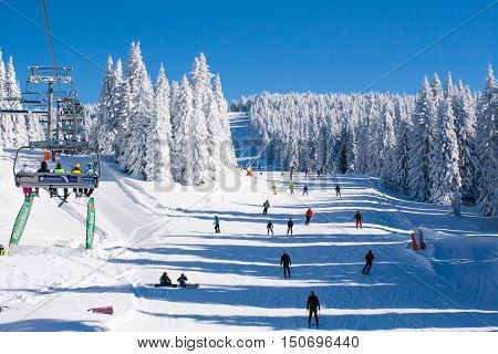 Kopaonik, Serbia - January 19, 2016: Ski resort Kopaonik, Serbia, ski slope, people on the ski lift, skiers on the piste among white snow pine trees