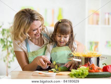 Mother teaches daughter cooking on kitchen