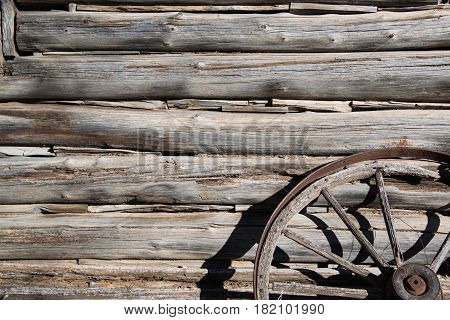 Hand cut logs barn wood from old cabin and wagon wheel background