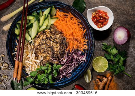 Bun bo nam bo asian food background with various ingredients on rustic stone background , top view. Vietnam or Thai cuisine.