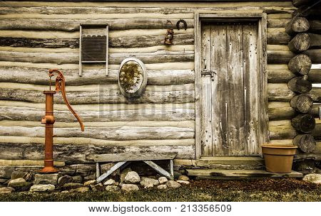 Rustic Log Cabin Exterior. Front door and exterior wall of a historical rustic log cabin with antique décor.