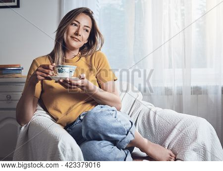 Woman drinking coffee at home. Woman relaxing with coffee at home. Modern lifestyle. Beautiful woman lifestyle portrait. Lifestyle. Concept of vacation lifestyle. Happy people lifestyle. Healthy people. Young people relaxing lifestyle. Lifestyle concept.