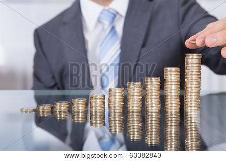 Businessperson With Stack Of Coins