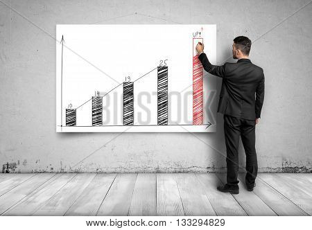 Businessman draws a potential benefit by increasing graph. Prosperous business. Economic and statistical graphs. Strategic calculation and research. Business idea. Business plan. Targeting success and happiness. Financial and business concept. Back view.