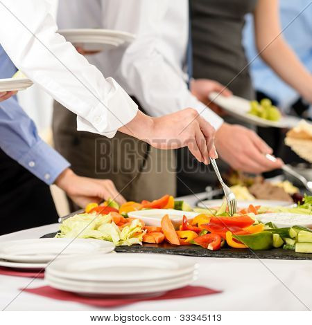 Business catering people take buffet food during company event