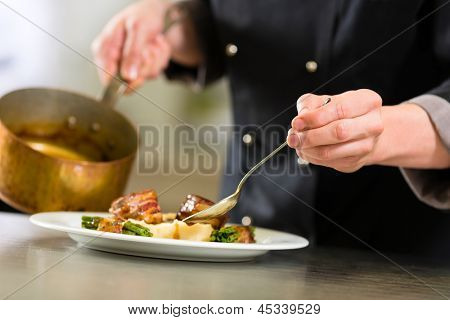 Chef-kok in een hotel of restaurant keuken koken, alleen handen te bezien, hij is bezig met de saus voor t